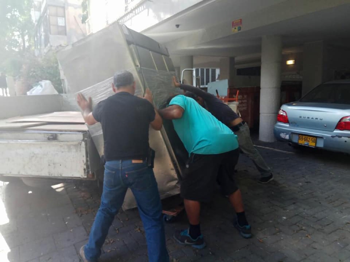 צוות ההובלה מעמיס מקרר מסחרי גדול